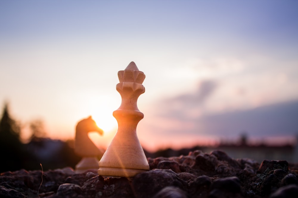 bishop chess piece on black rock at daytime