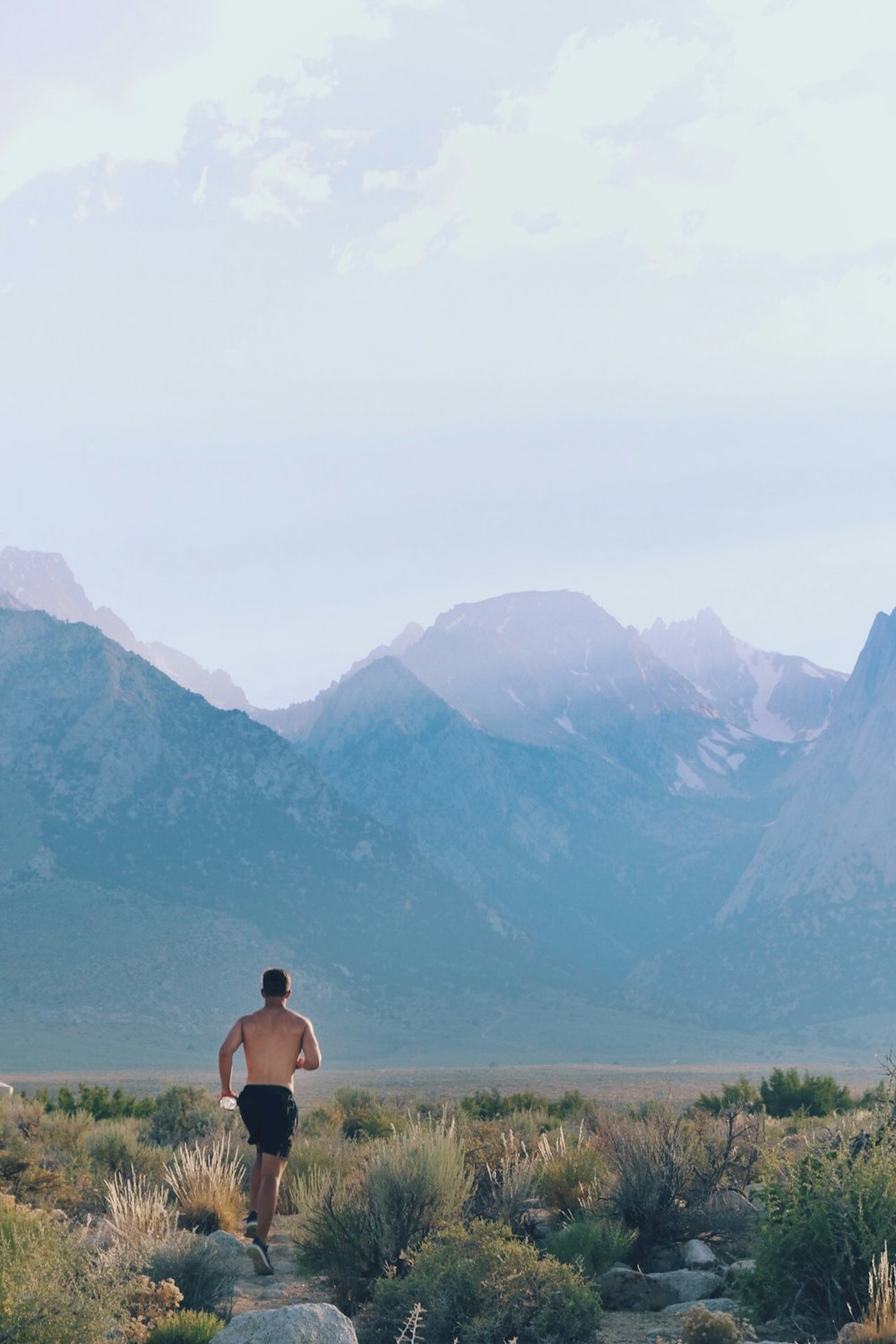 topless man jogging in green field