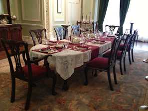 An elegant dining table made from rich wood, set with simple, tasteful tableware.