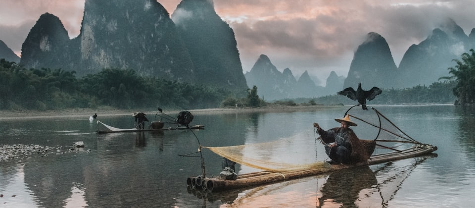 Sunset on the Li River as the few remaining cormorant fisherman pack their.