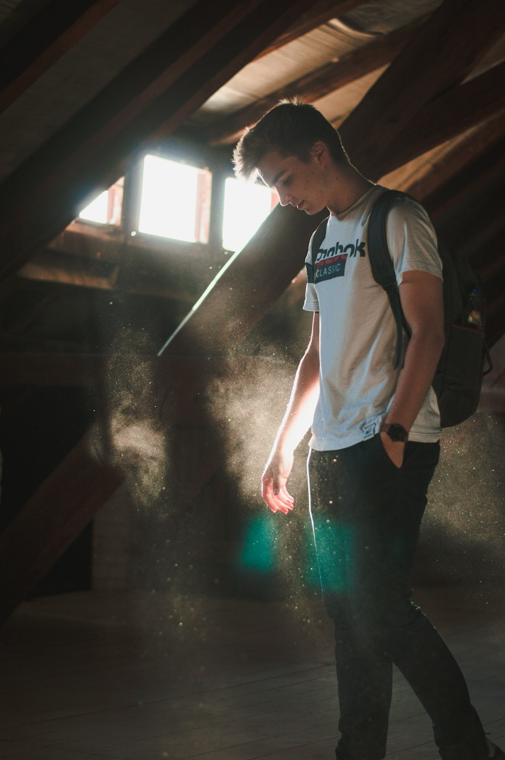 man standing near wall illuminated with sunlight