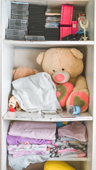 A neatly organized nursery shelf with baby essentials and soft toys.