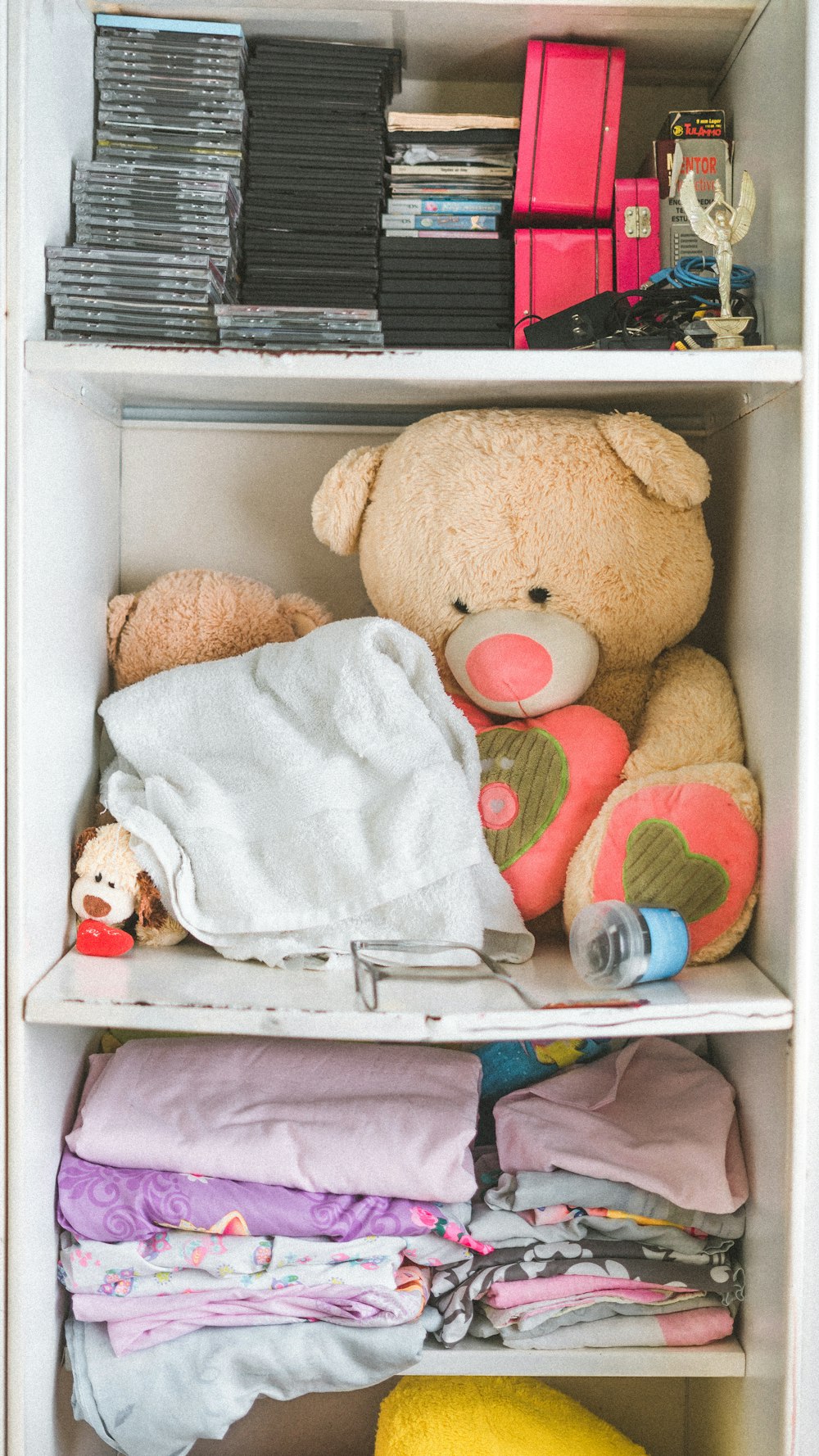 brown teddy bear inside cabinet