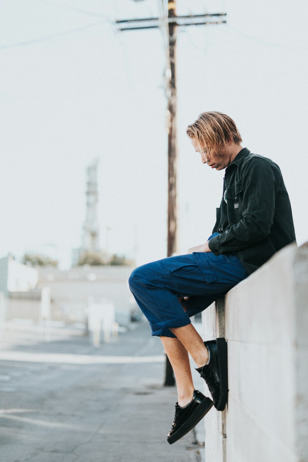 man sitting on gray wall