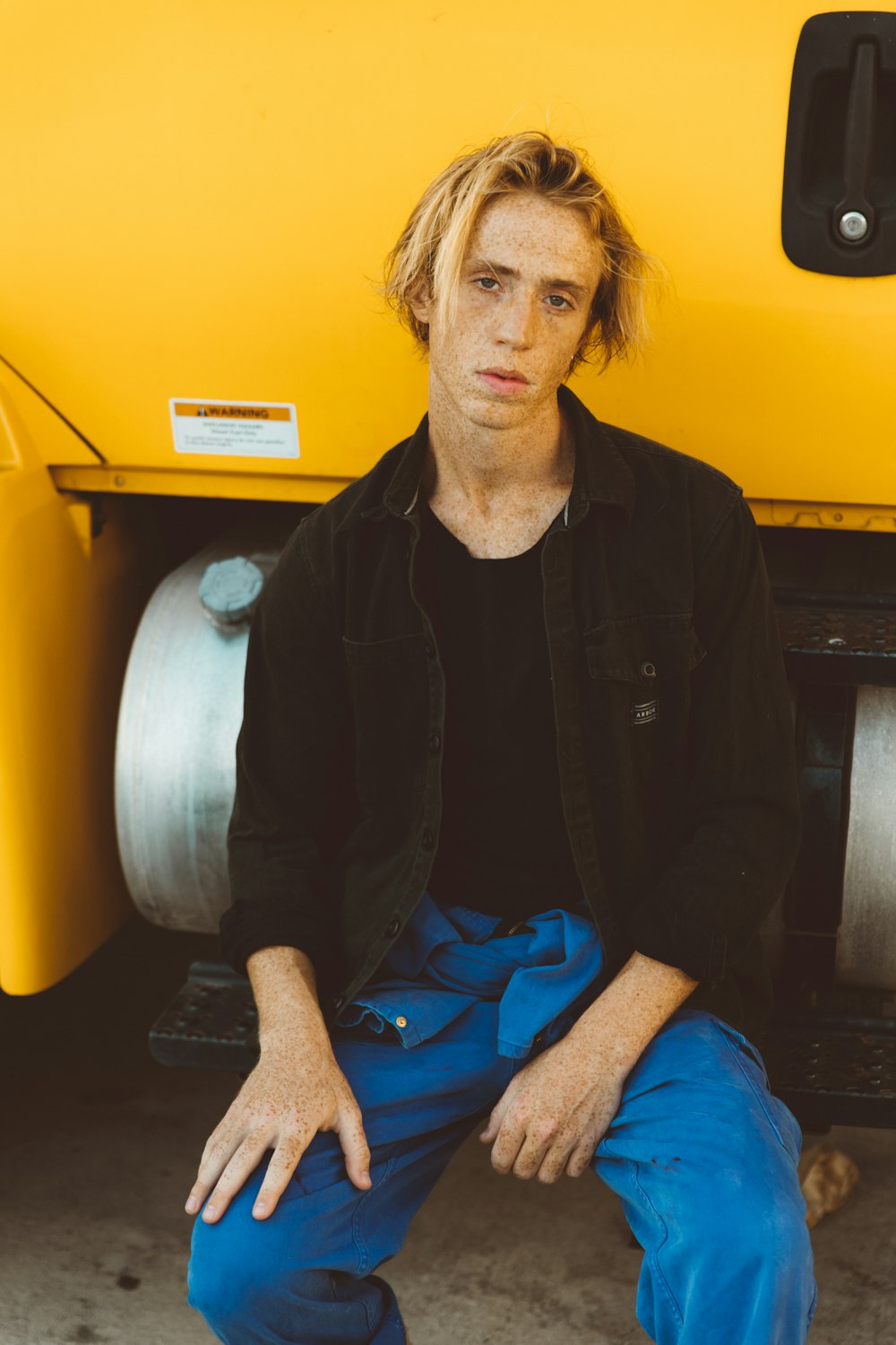 man sitting on truck side-step bar