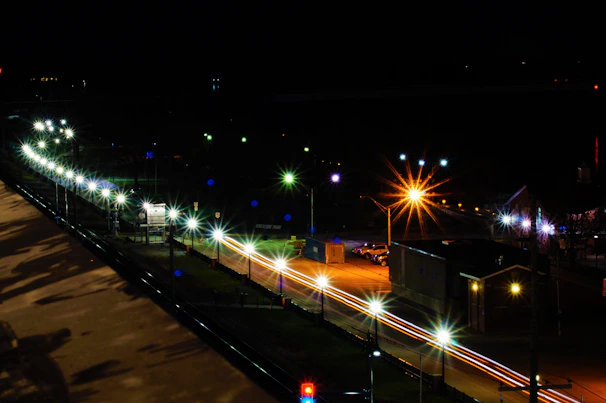 A nighttime cityscape with streetlights casting long shadows.