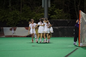 Action shot of Methacton Warriors players celebrating a goal in dark green and white uniforms.