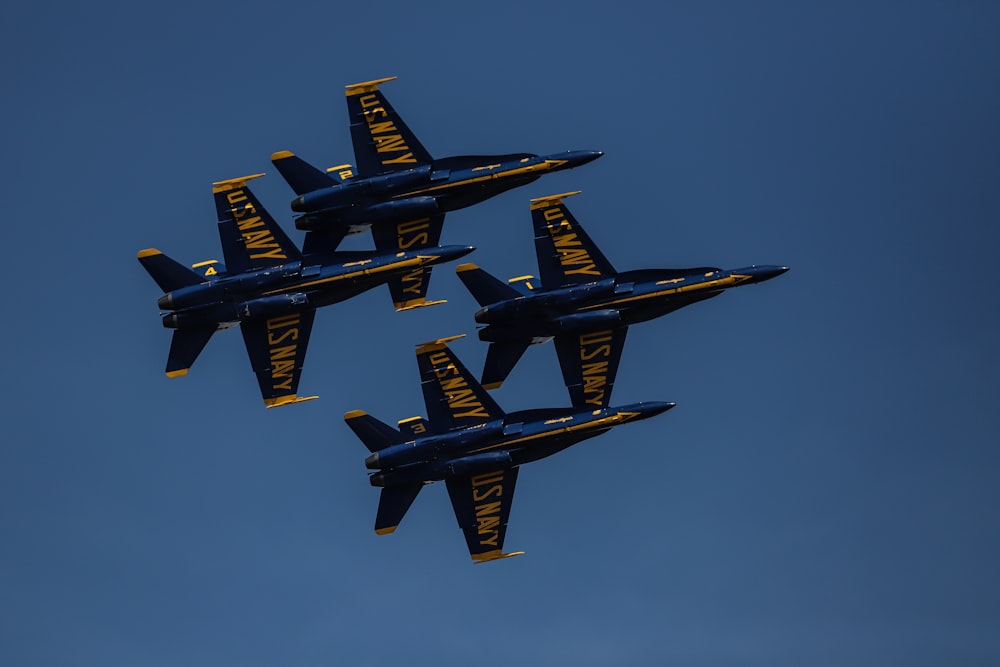 four black and yellow jet fighters