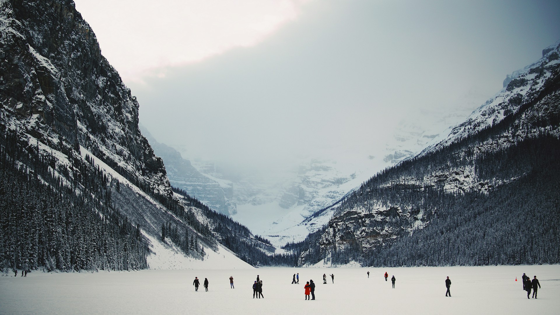 An adventurous group crossing a shimmering glacier on the way to Snow Lake, surrounded by towering snowy peaks.