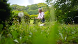 A woman journaling with a peaceful garden in the background