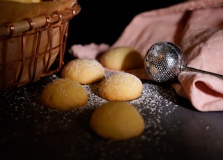 baked biscuits near basket on black surface