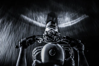 Dynamic black and white photo of a rider leaning into a sharp turn on a winding road.