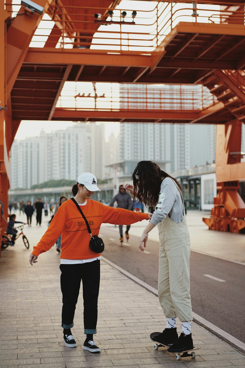 woman holding person on skateboard