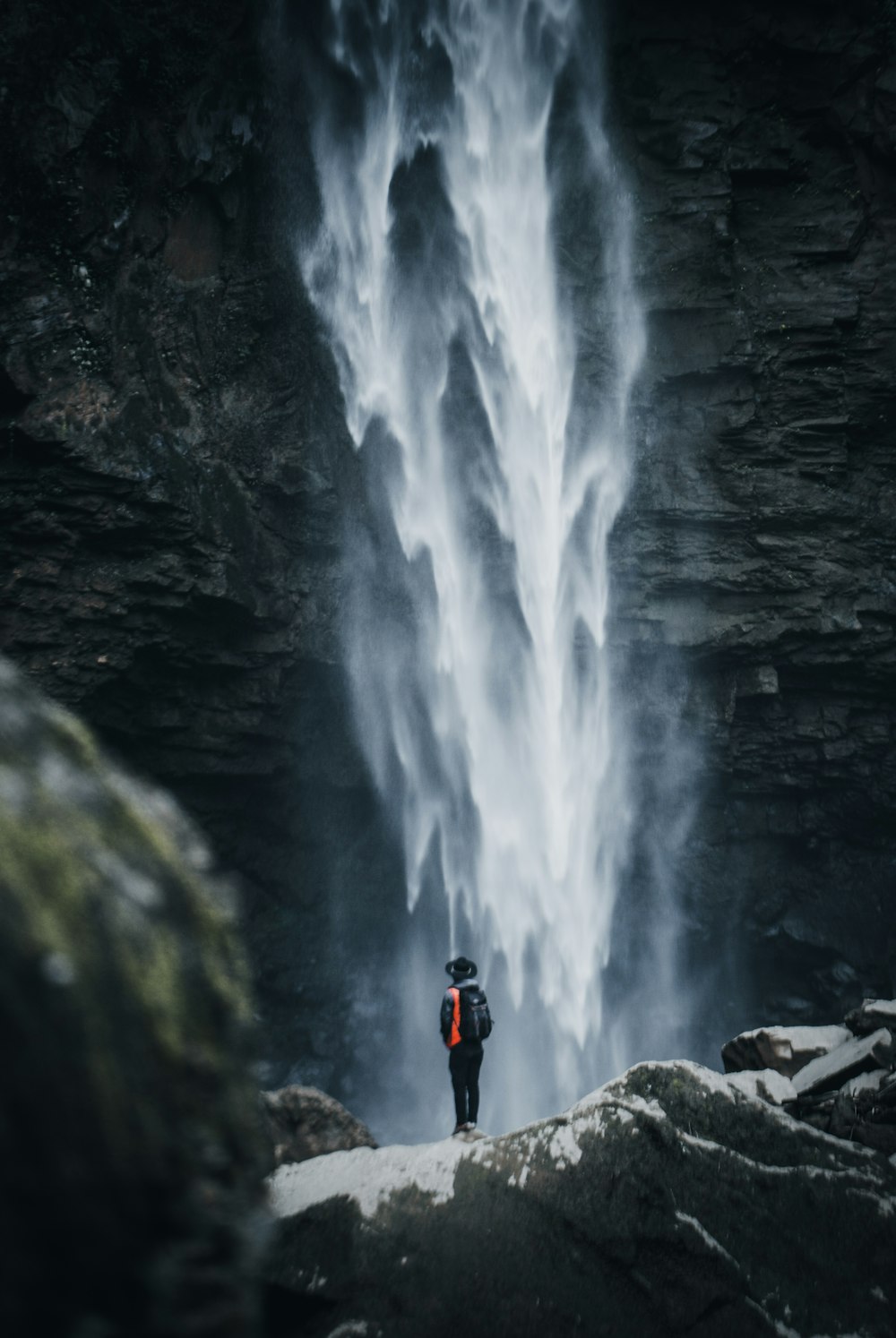 man standing near waterfalls