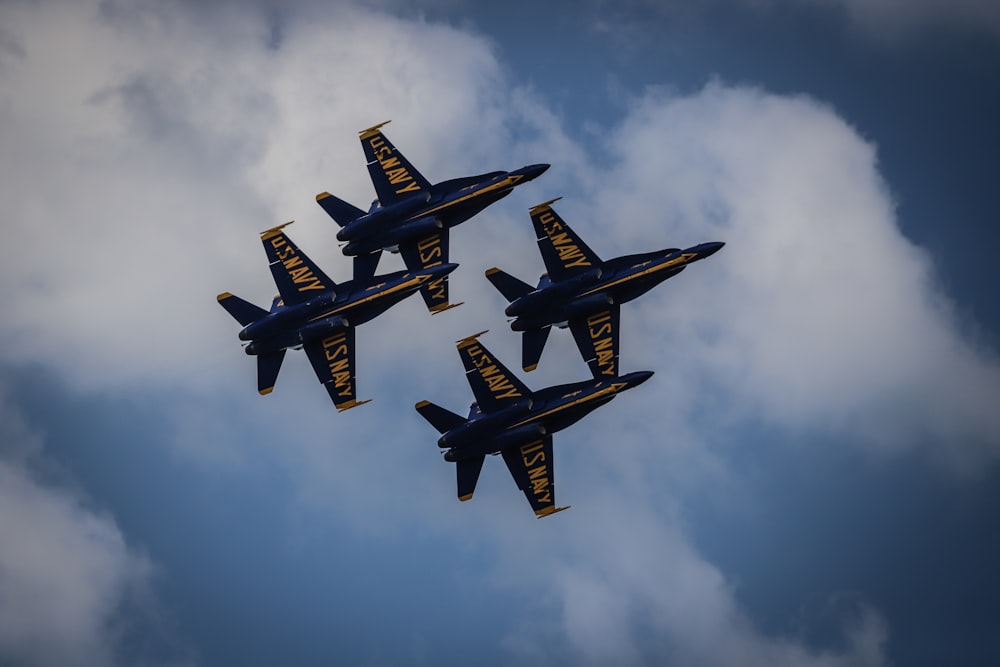 four yellow-and-black jets on sky