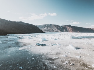 A panoramic view of a Greenlandic port under construction amidst rugged Arctic terrain.