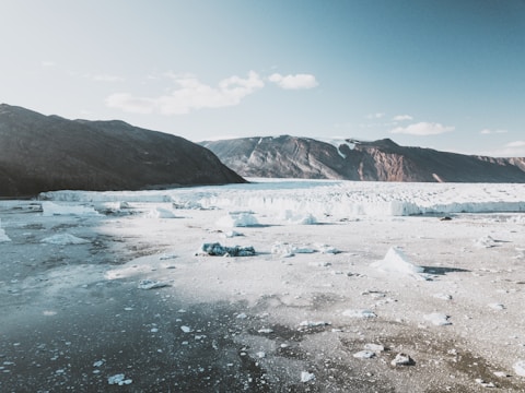 A panoramic view of a Greenlandic port under construction amidst rugged Arctic terrain.