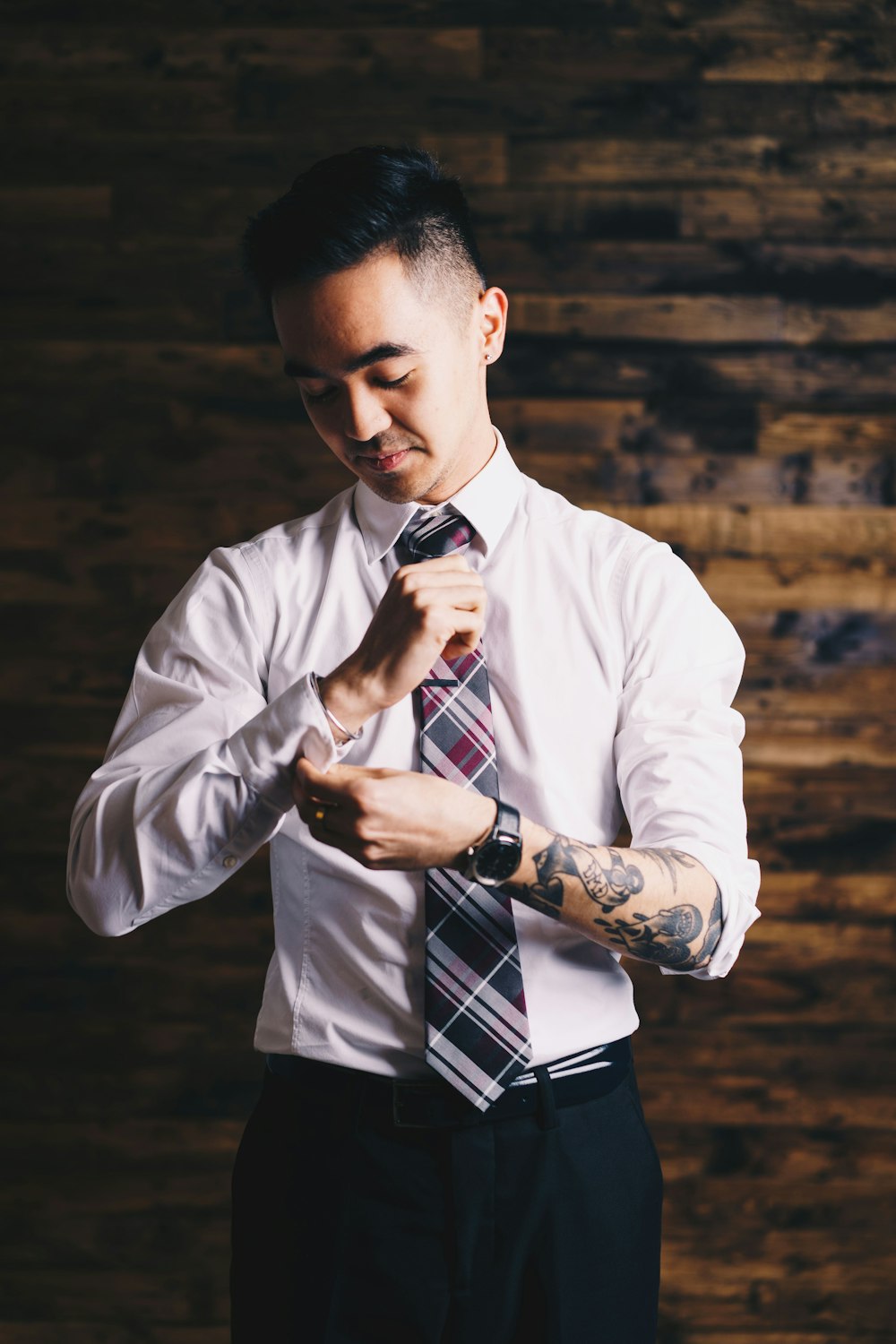 man holding his sleeve and necktie