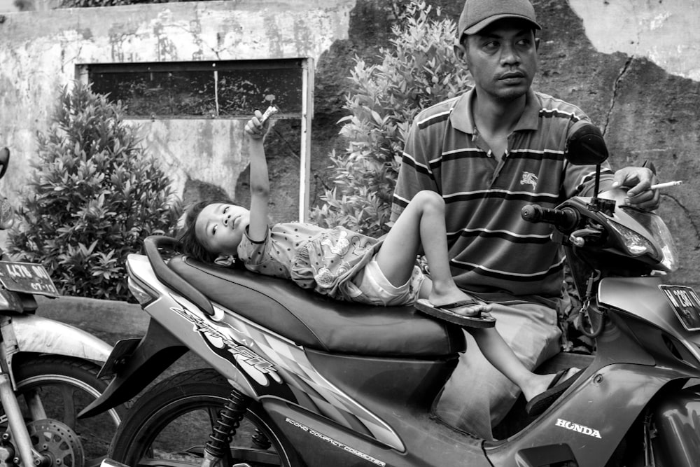 grayscale photography of boy on motorcycle
