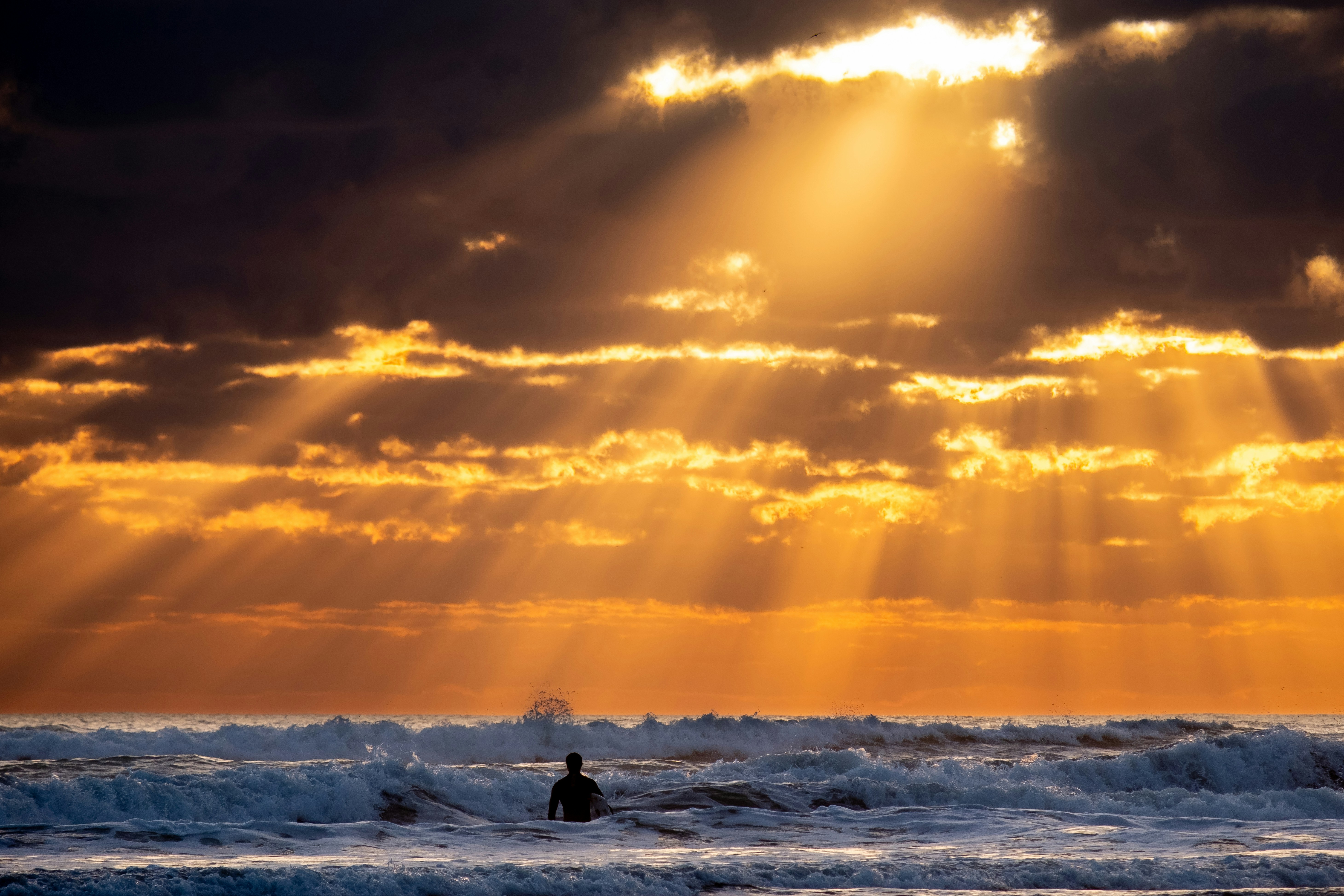 surfeurs au coucher de soleil sur la plage