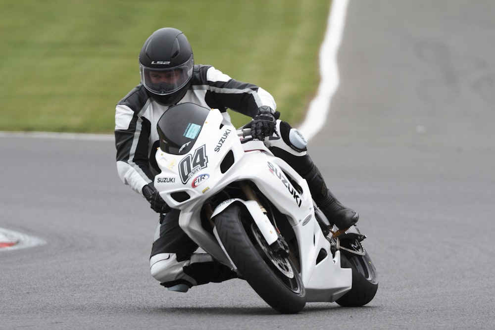 man riding white and black Suzuki sportbike