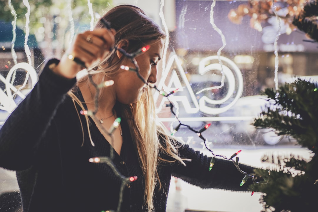 woman holding string lights