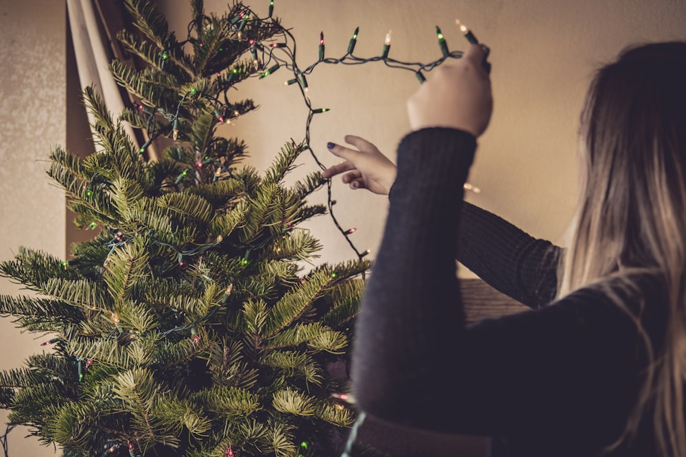 woman holding string lights