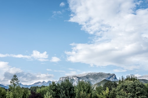 A scenic landscape featuring mountains and a clear blue sky.