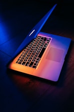 Technician performing hardware diagnostics on a sleek laptop with blue lighting.