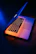 A refurbished laptop battery resting on a futuristic dark surface with cyber-style blue lighting.