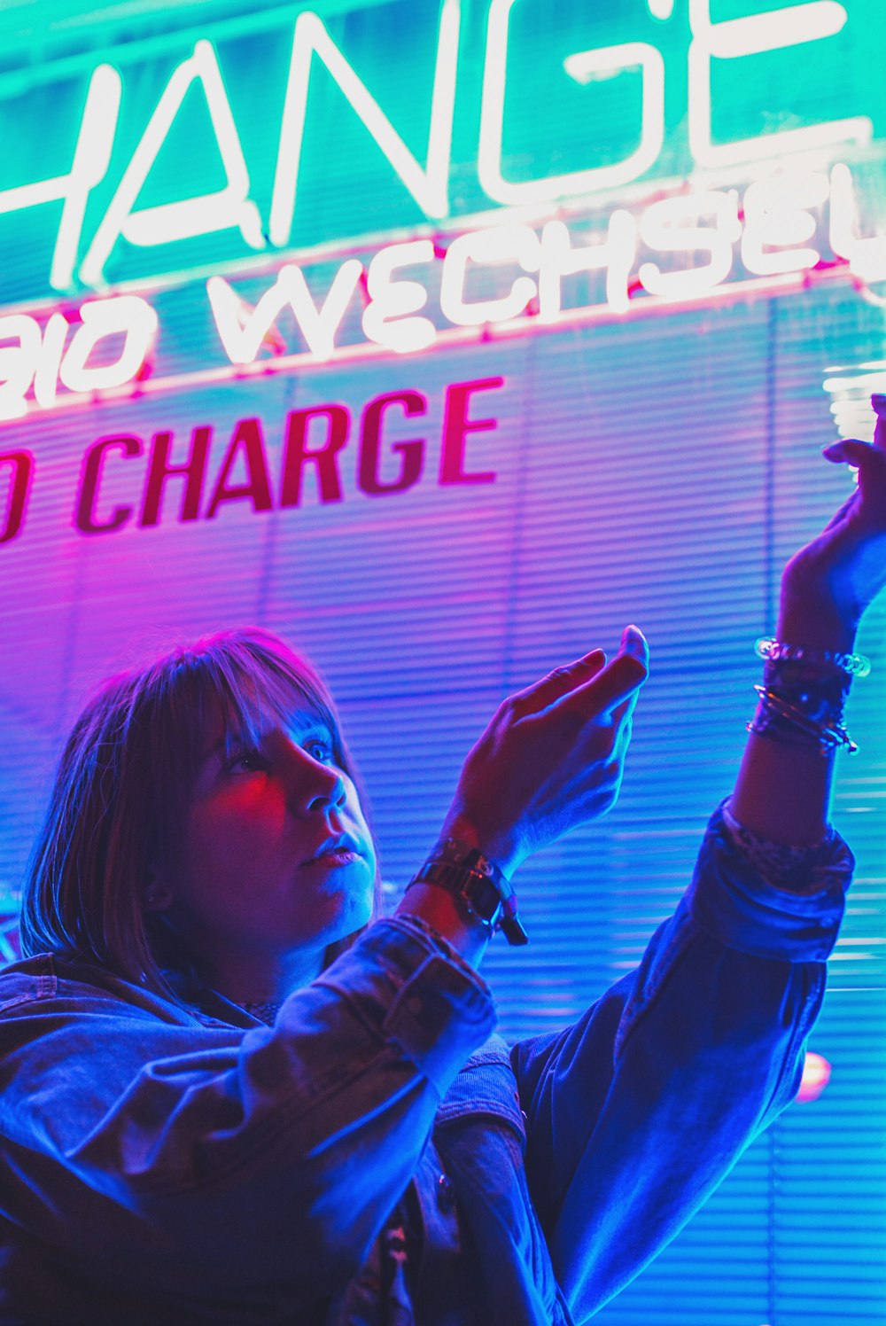 woman about to touch white and blue neon signage