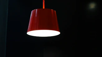 Close-up of a modern lamp with a bold discount tag glowing in red, set against a clean white background.