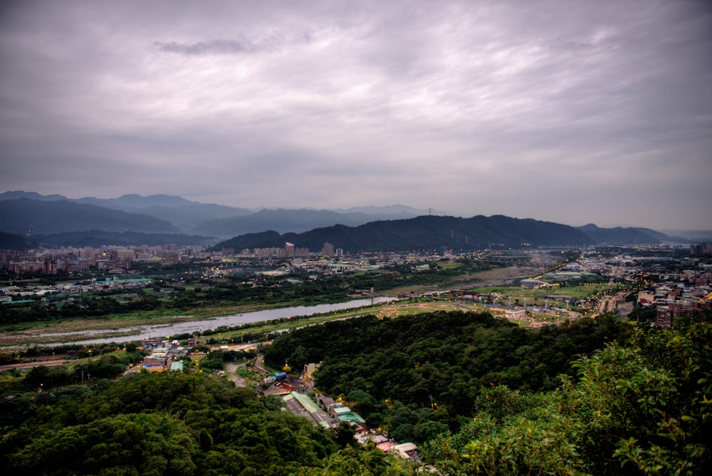 aerial photo of land with buildings and trees under gray clouds during daytime