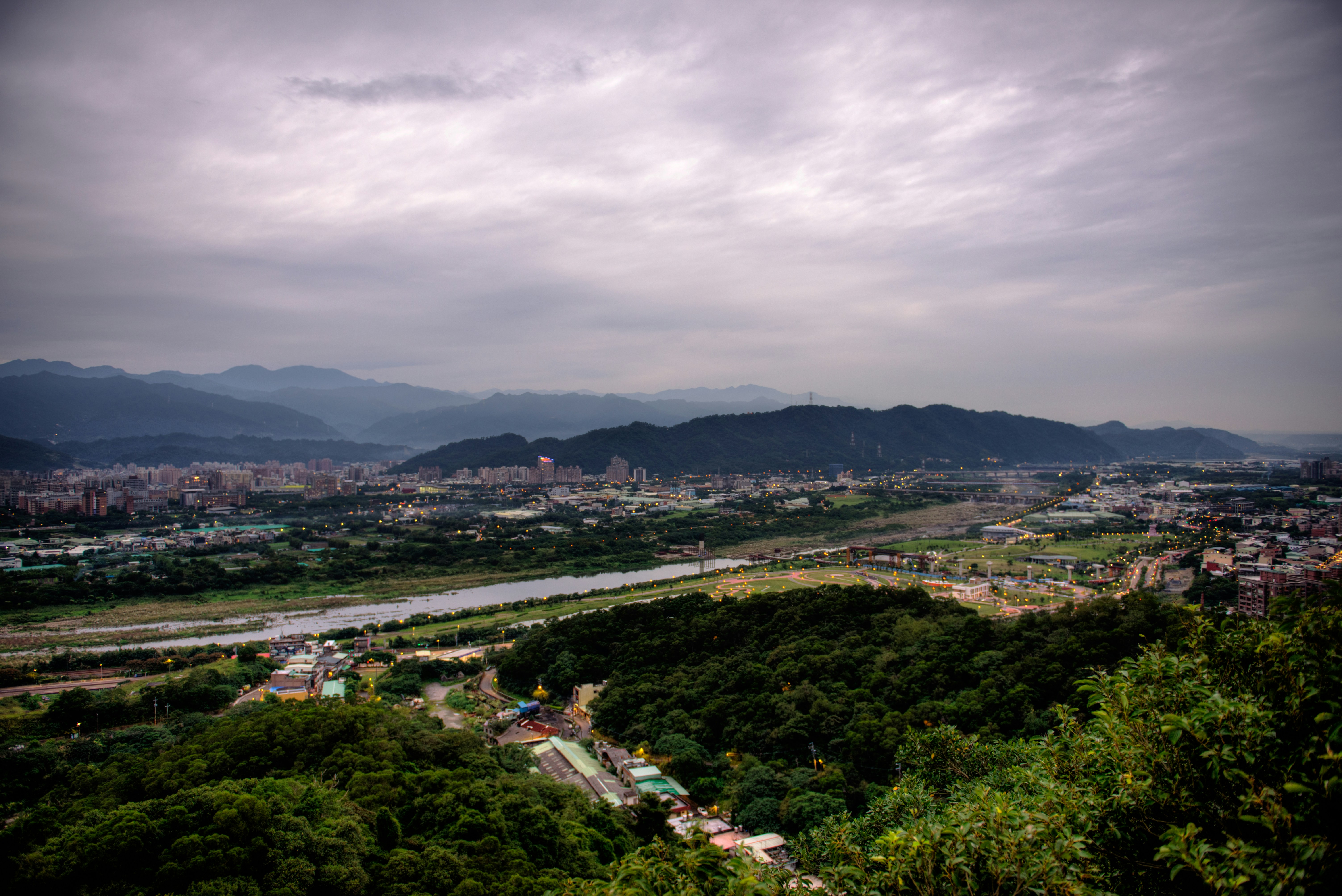 aerial photo of land with buildings and trees under gray clouds during daytime