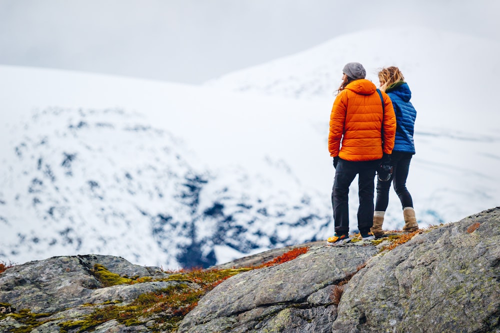 two women standing on rock formation during daytime