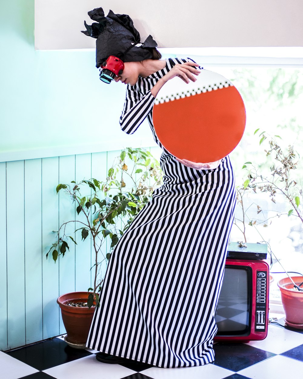 woman holding round paper wearing VR headset