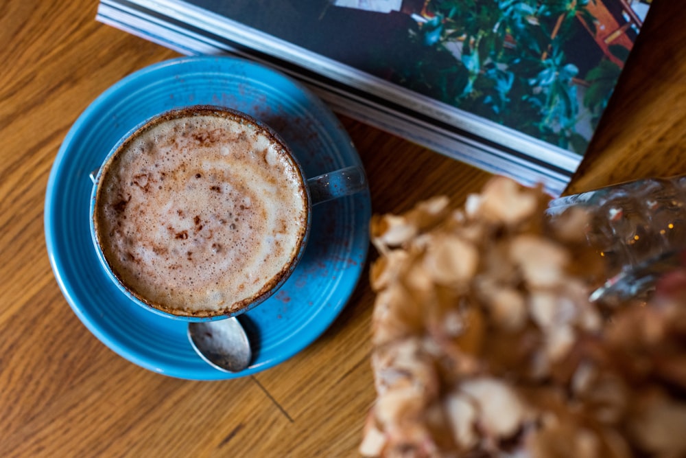 blue ceramic coffee cup filled with coffee