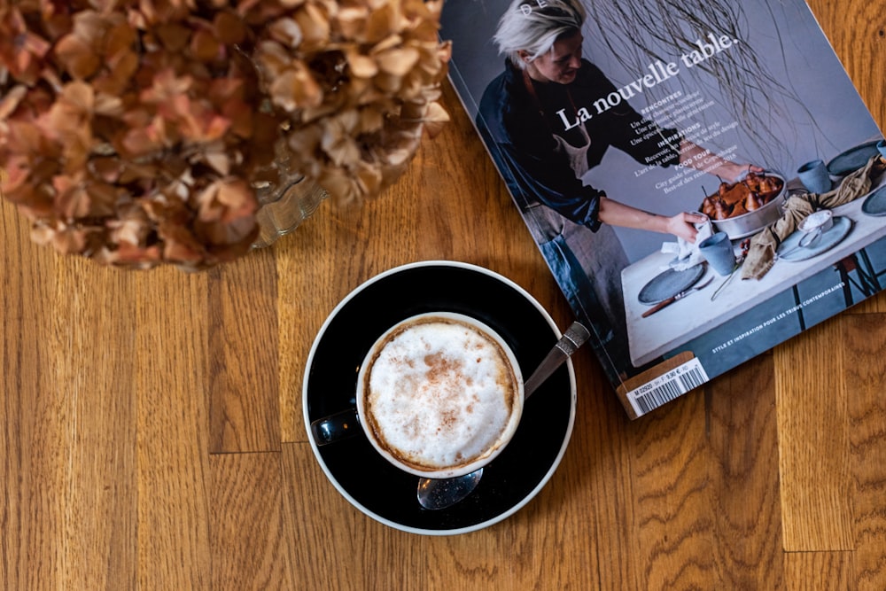 cup of cappuccino beside La Nouvelle Table book