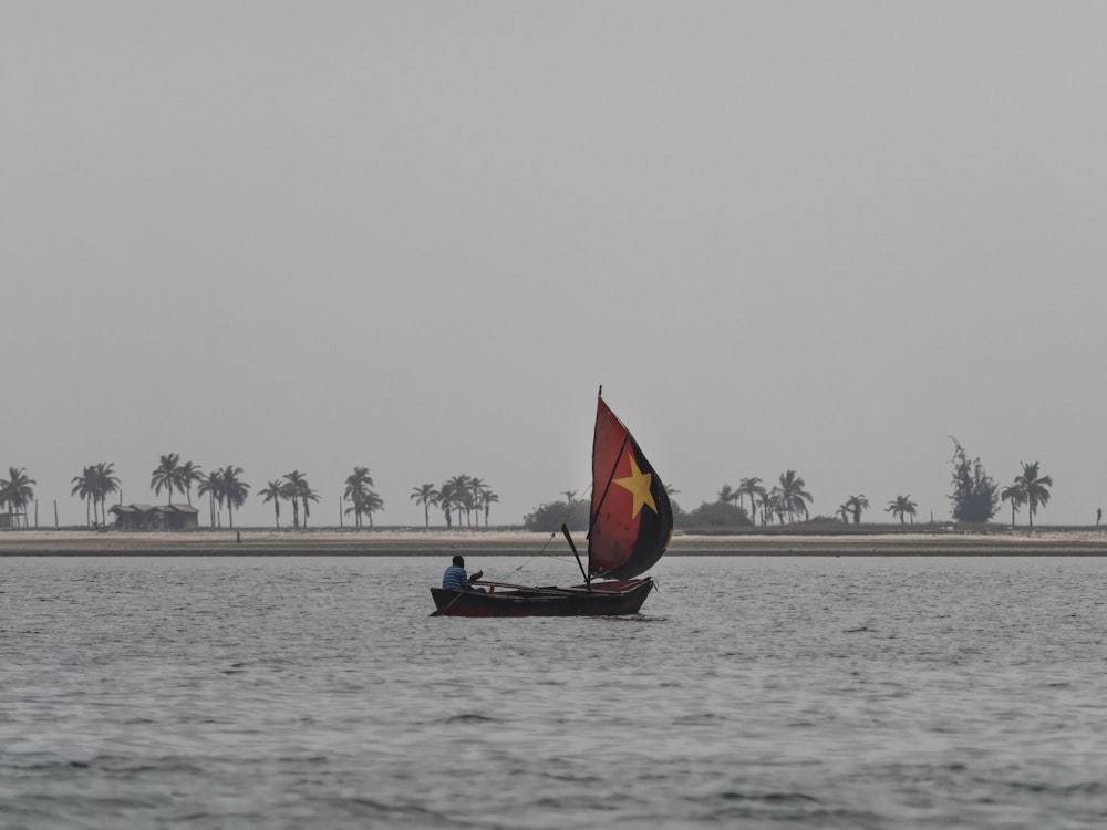 man on sailboat on sea during daytime