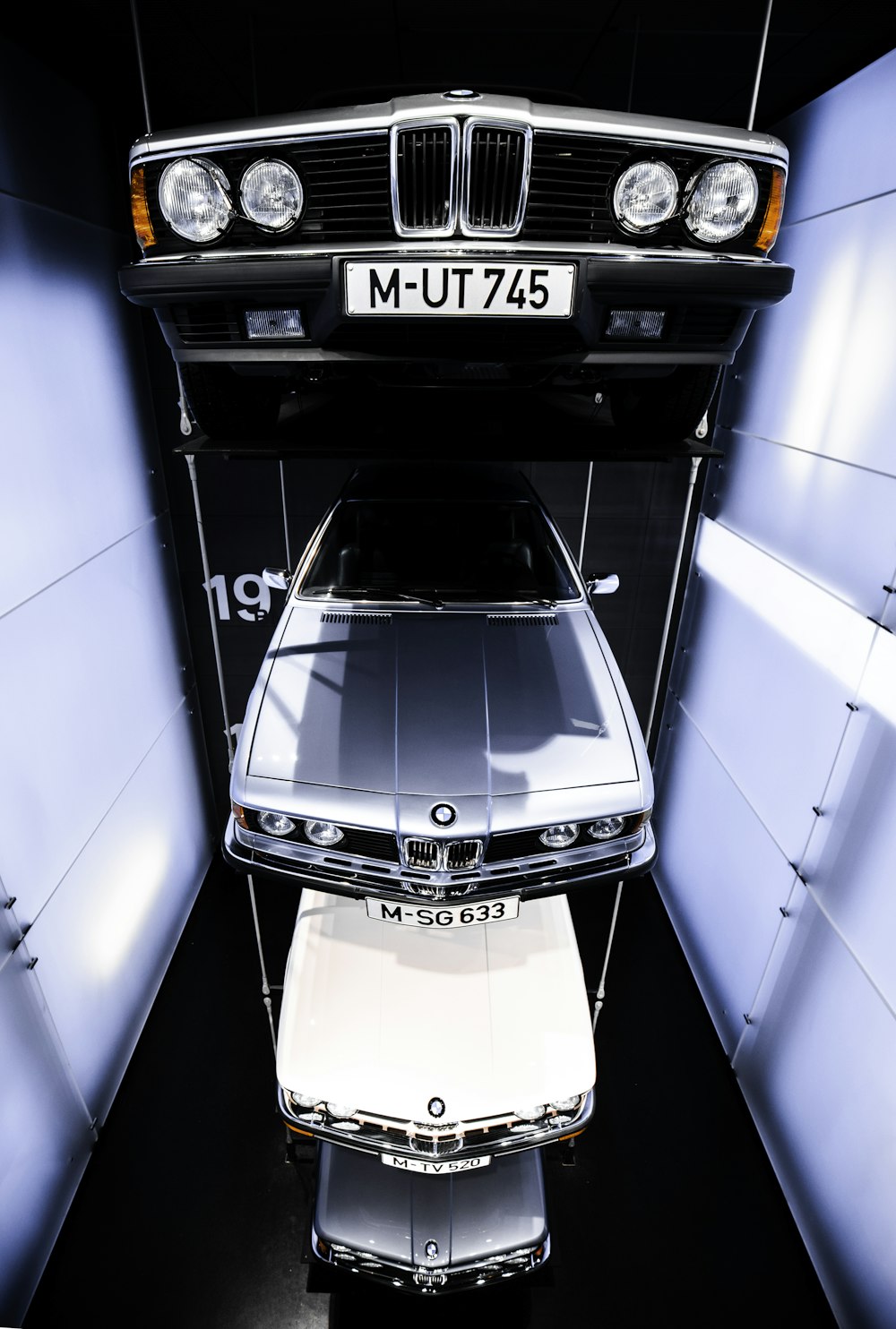 varios vehículos BMW suspendidos en el aire dentro de la sala de exposición