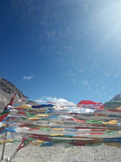 A vibrant sunset over the Himalayan mountains with colorful prayer flags fluttering in the breeze.