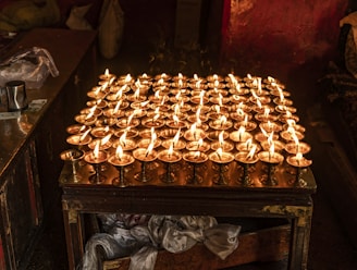 Rows of brass oil lamps glowing softly in a dimly lit room.