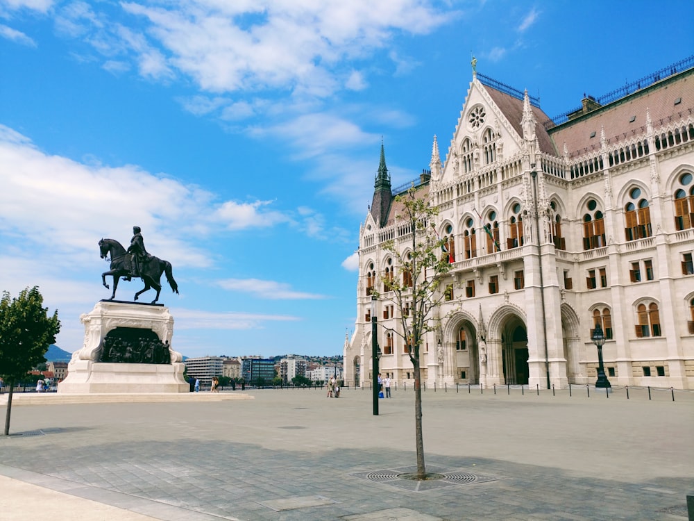 man riding horse statuette in front of building