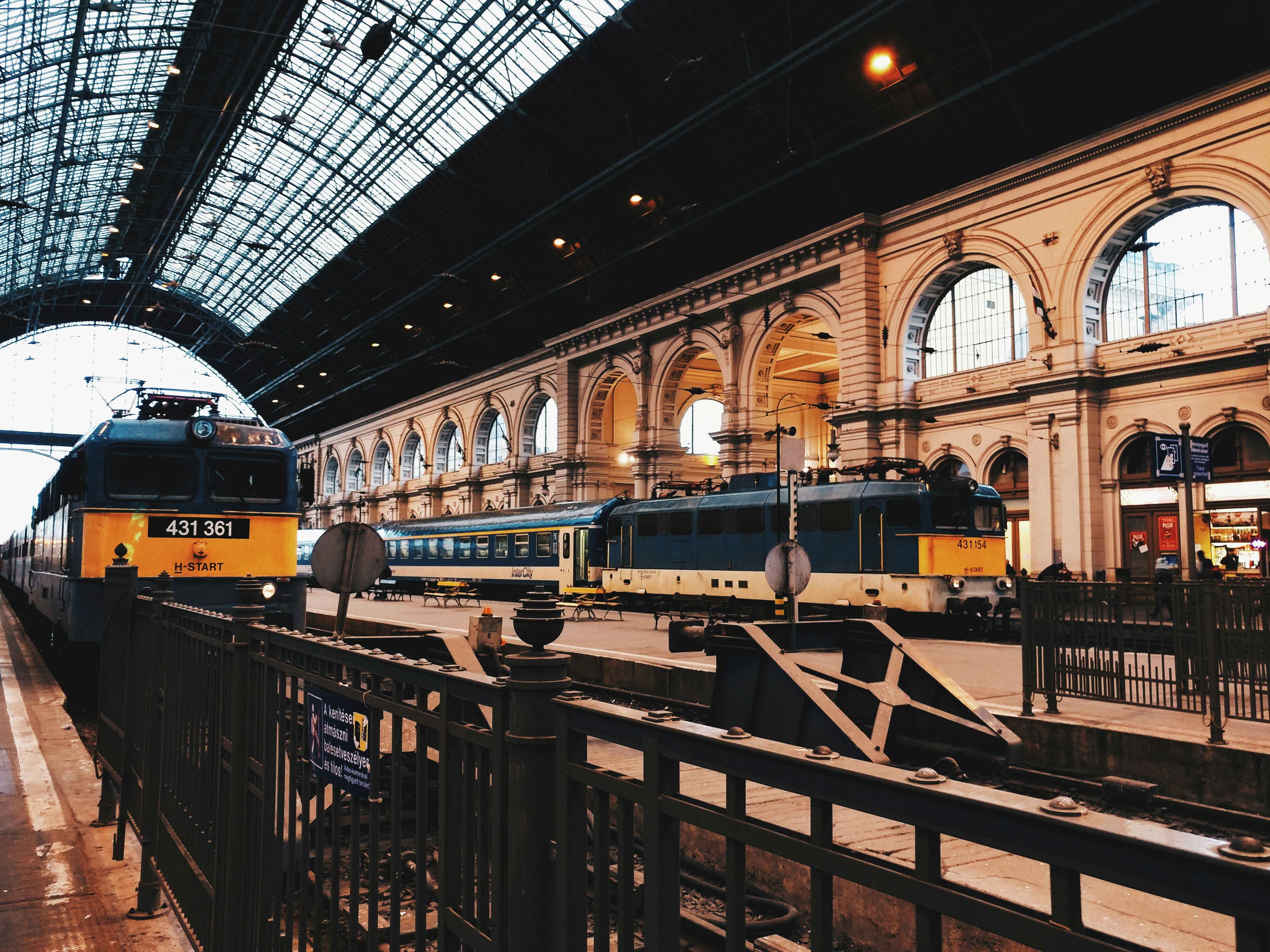 two black-and-yellow trains on train station, 