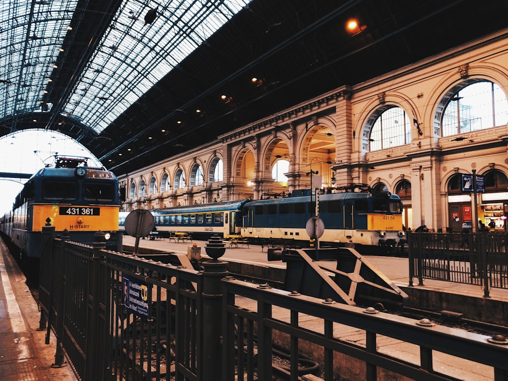 two black-and-yellow trains on train station