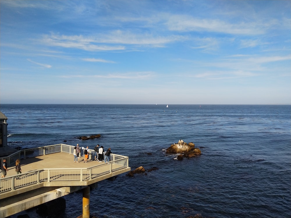 group of people standing in front of sea