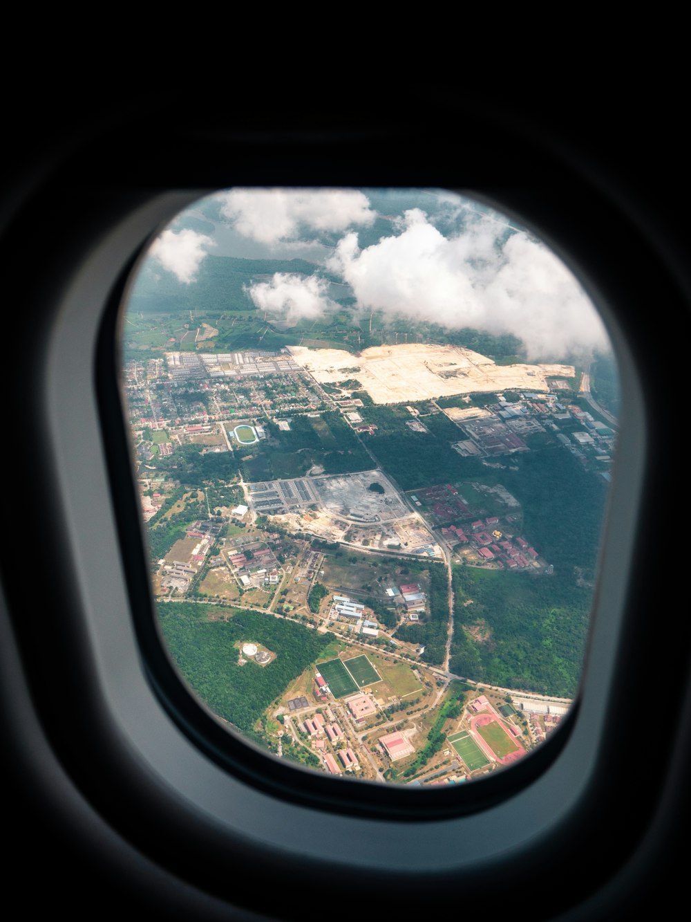 aerial photography of rural area through plane window