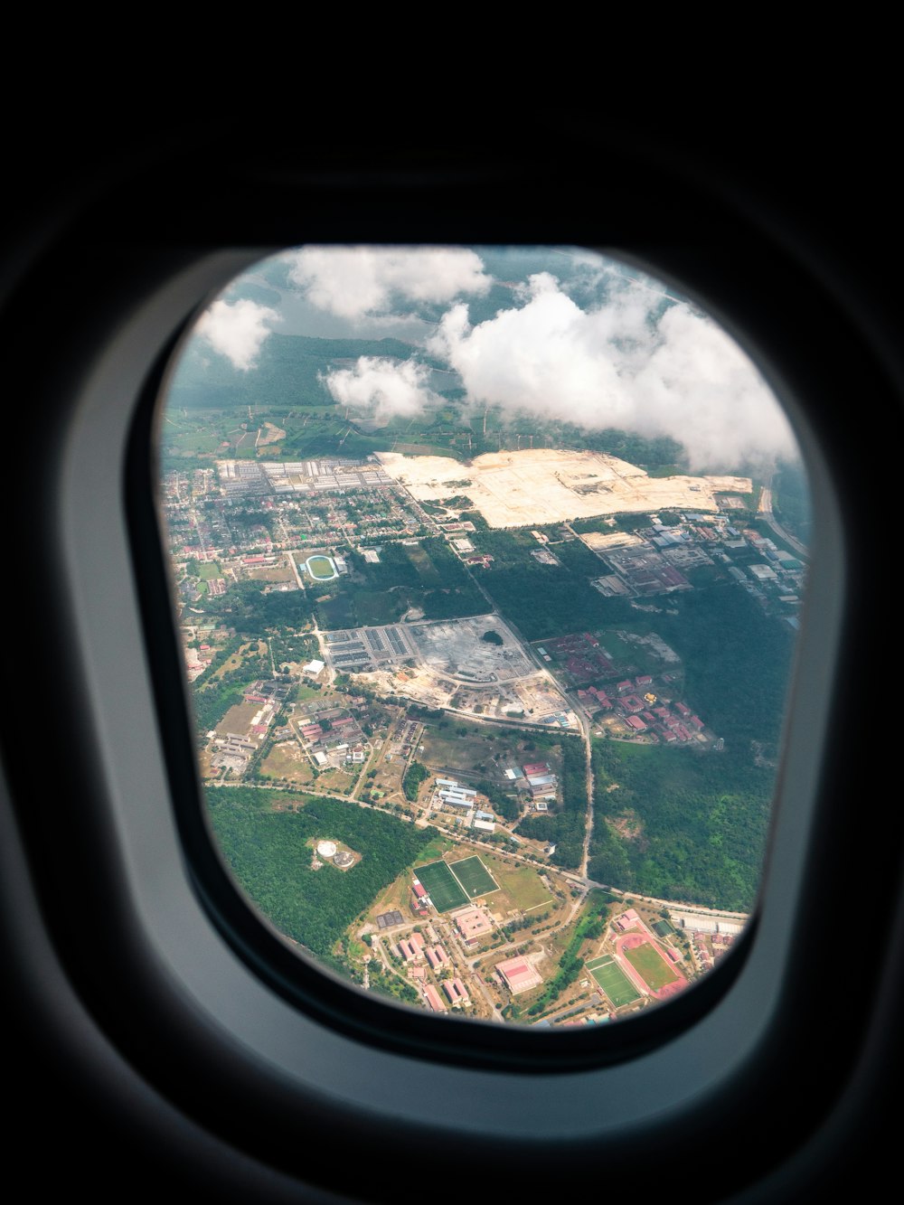 fotografia aérea de área rural através de janela de avião