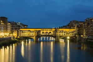 A historic bridge spanning a picturesque river at sunset.