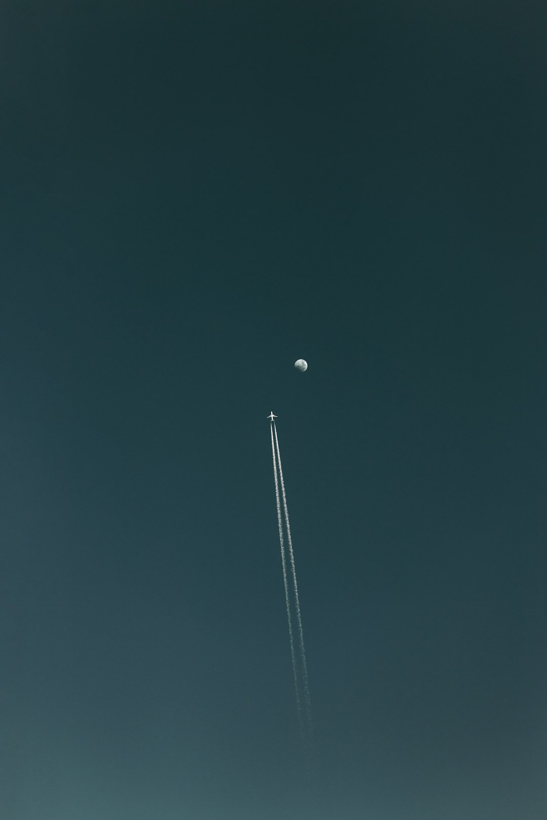 flying plane with contrail during nighttime